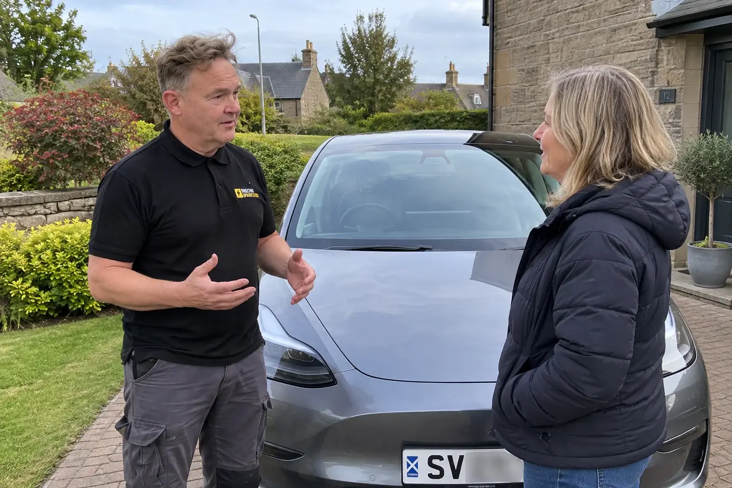 James talking with a car owner on a driveway